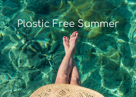 plastic free summer, woman legs wearing a large straw hat by the sea